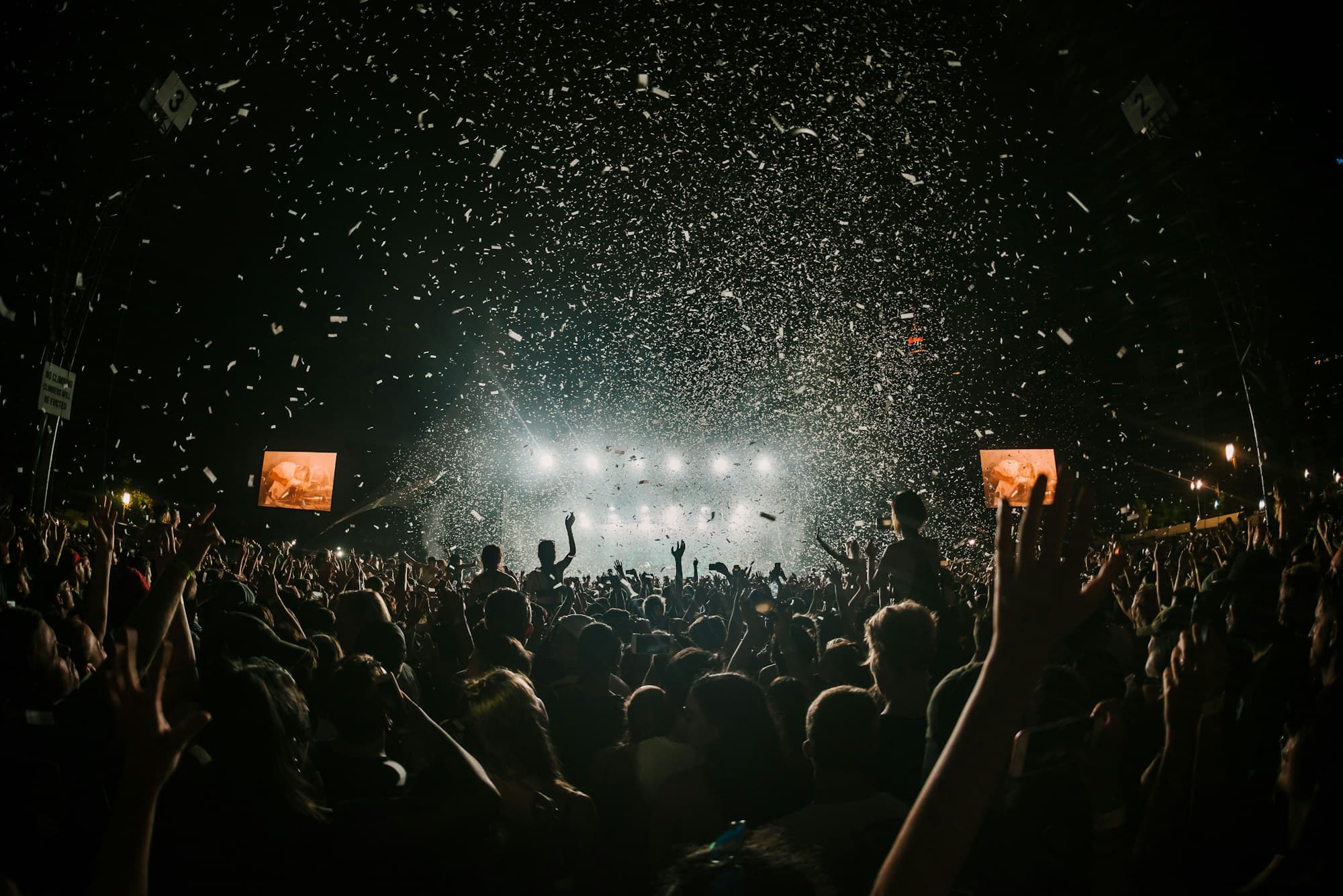 A performer commands the stage as a festival crowd watches below