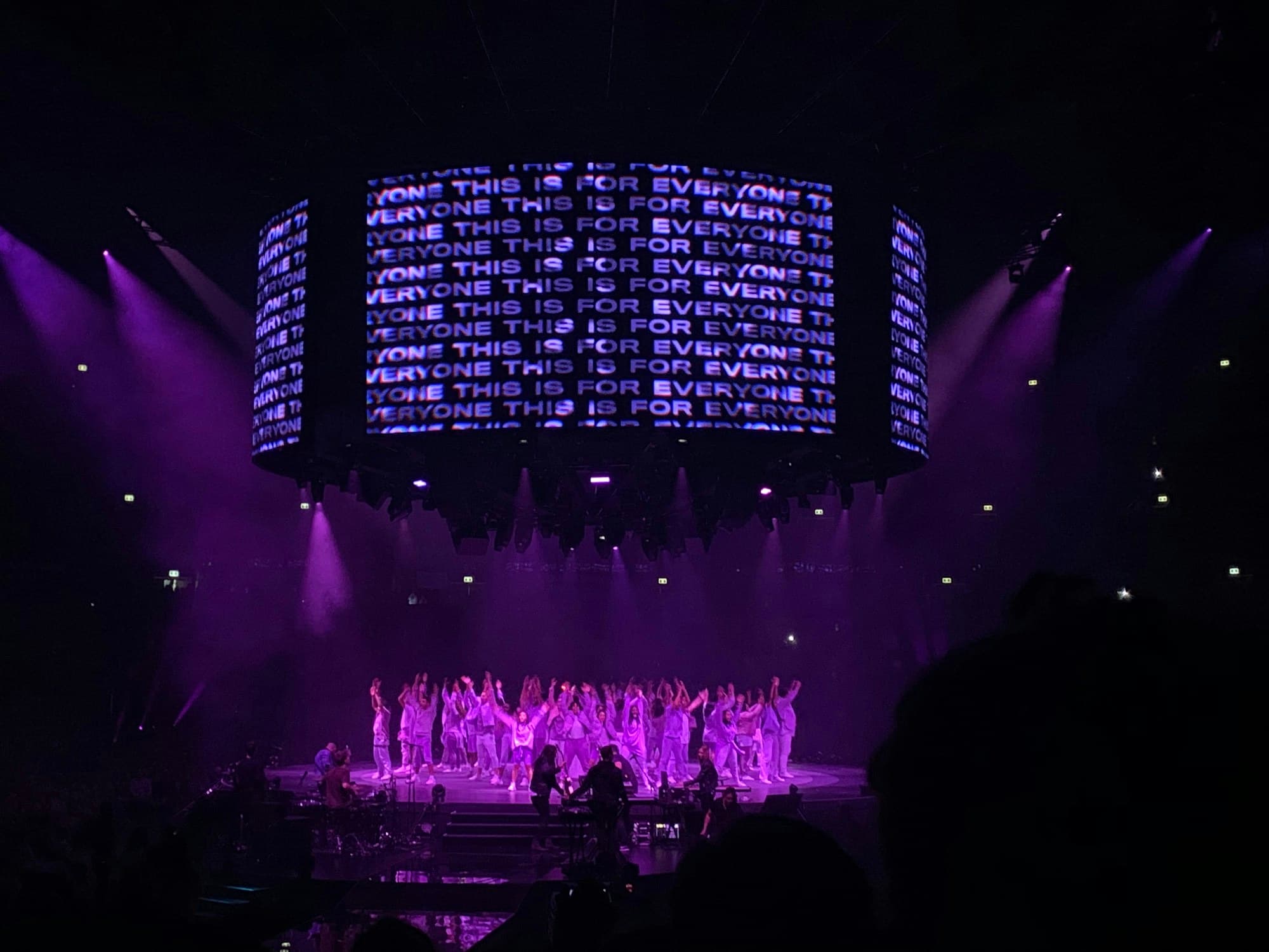 Performers on stage in front of violet LED lighting