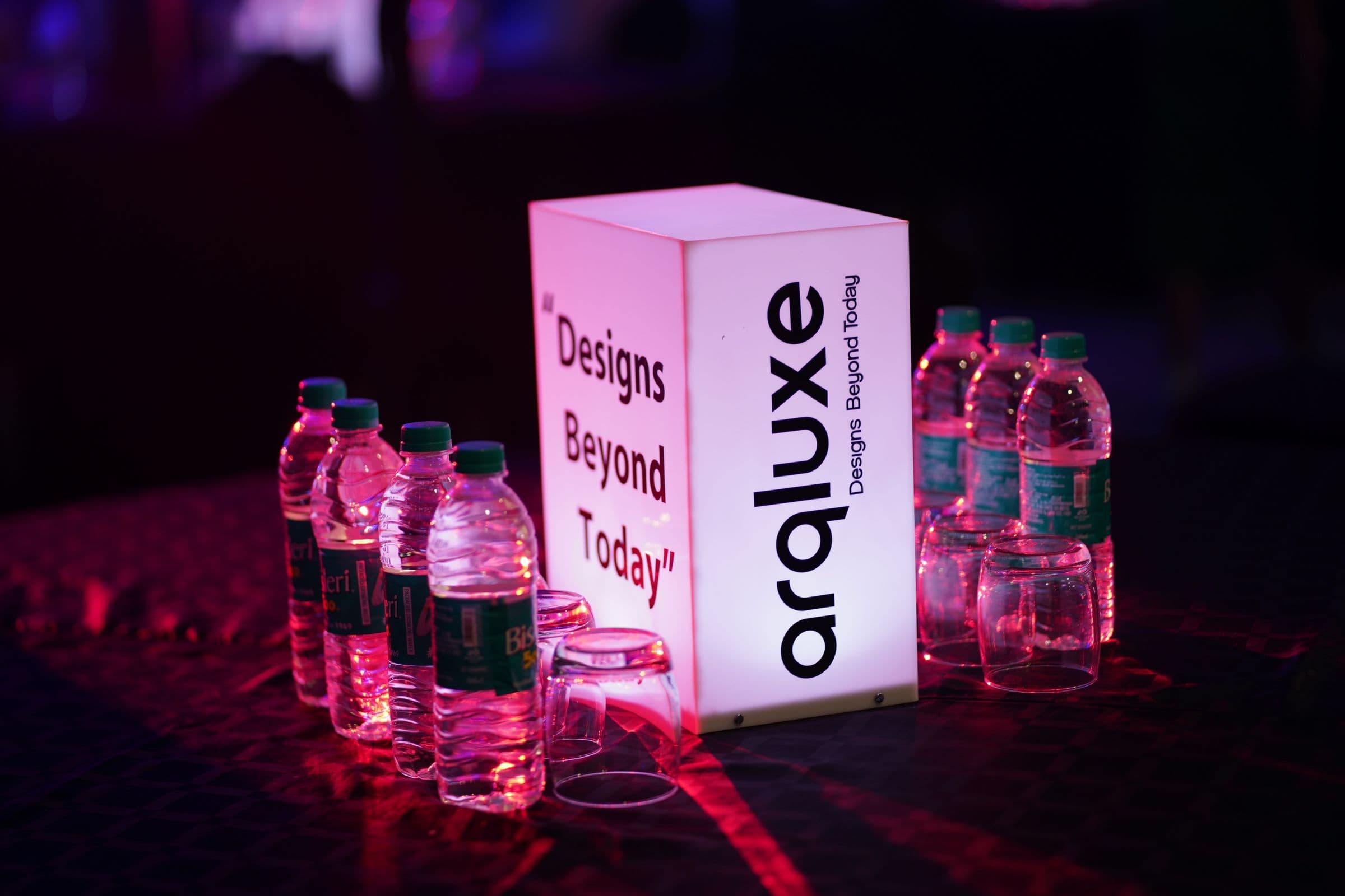 A glowing branded display cube at the Arqluxe launch