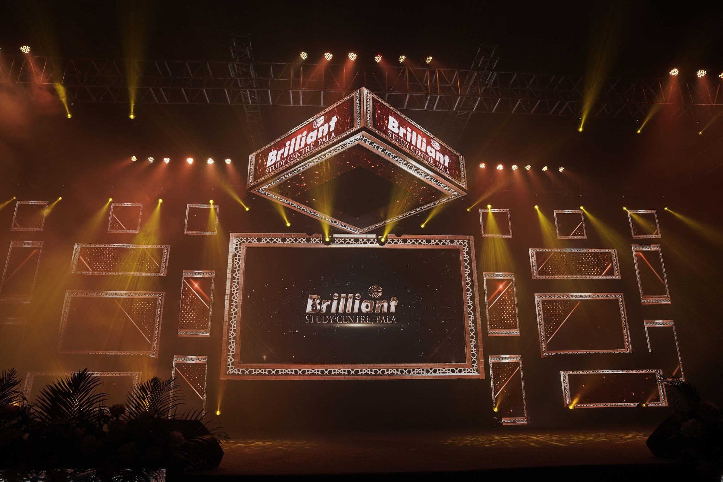 A large stage set lit in amber with the Brilliant centrepiece