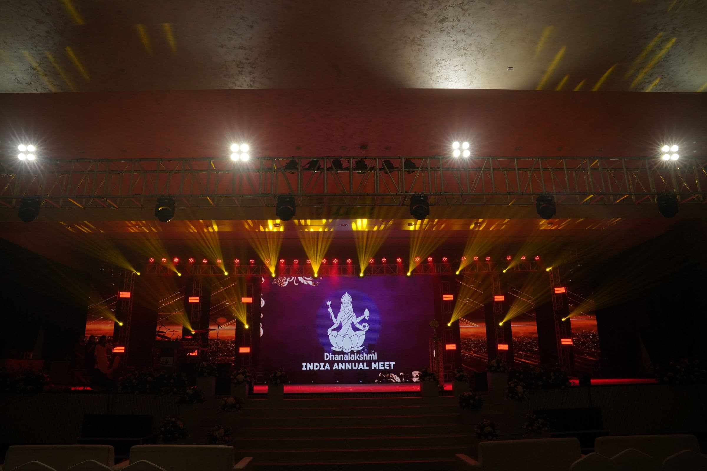 The stage for the Dhanalakshmi India Annual Meet, lit in purple