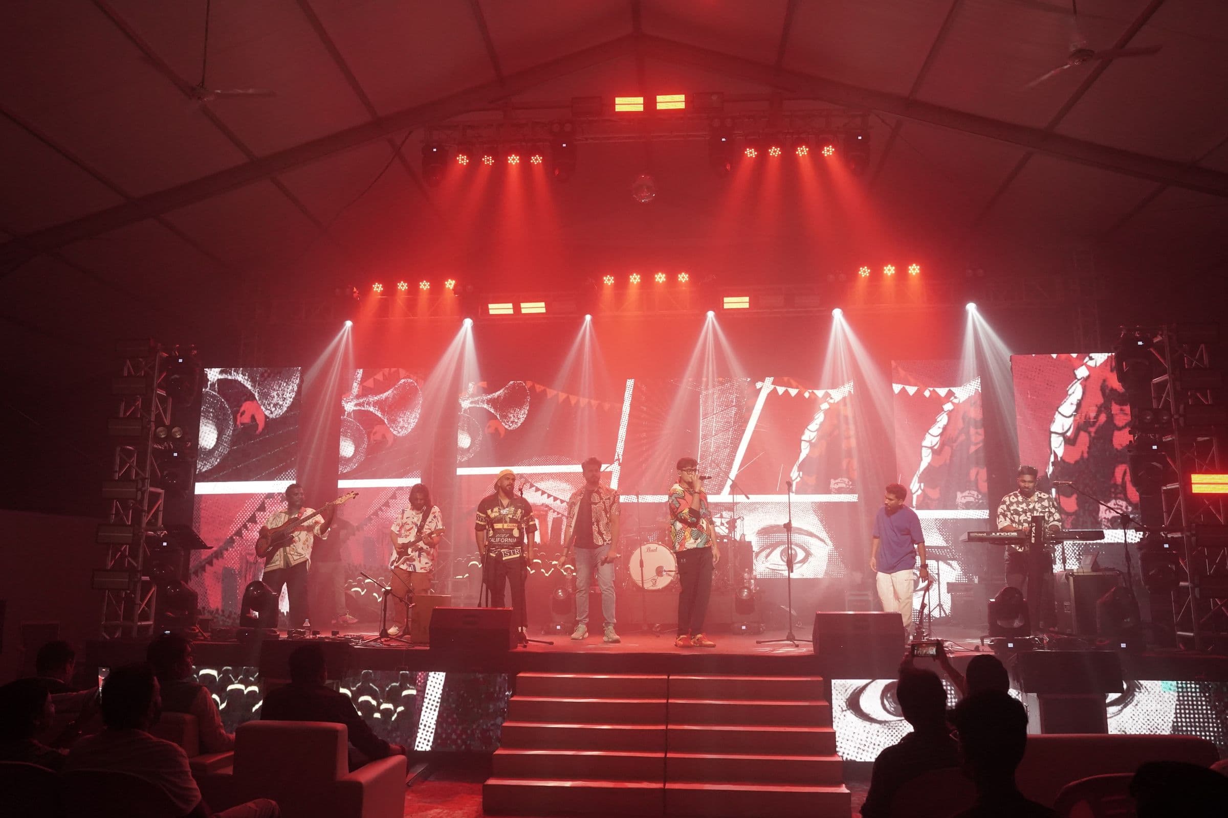 A red-lit stage performance under a full lighting rig