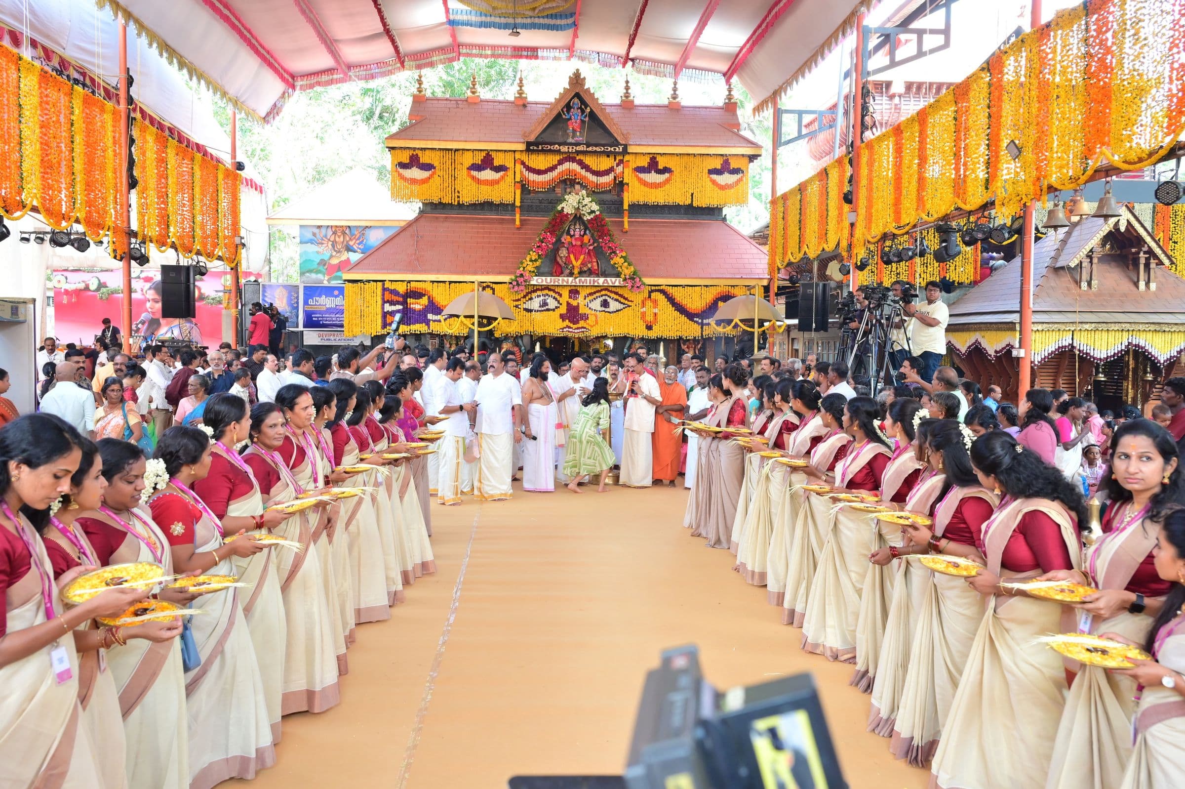 Women in Kerala sarees form a welcome line with traditional lamps