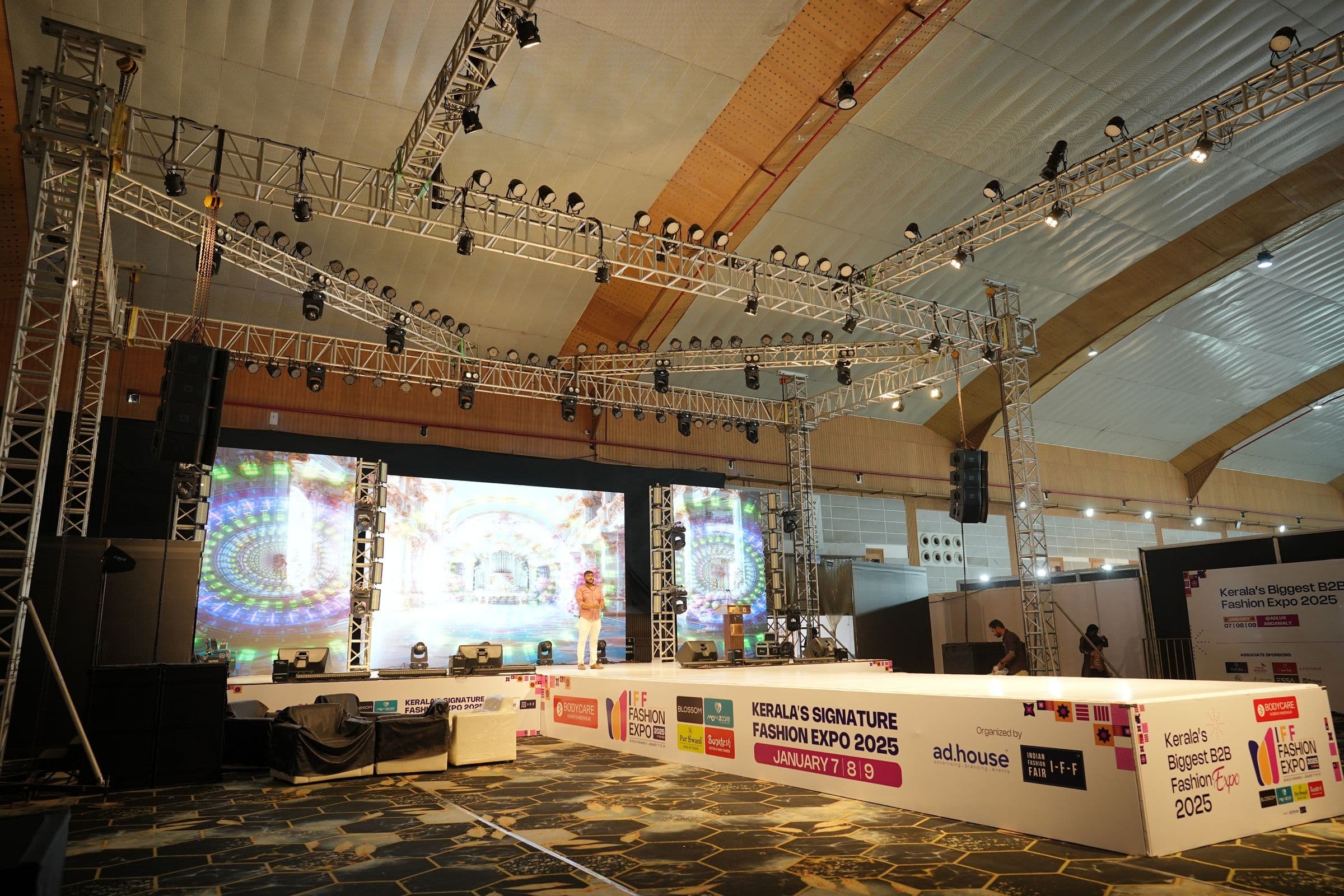 A truss-roofed exhibition hall with a stage and LED screen at IFF Fashion Expo 2025