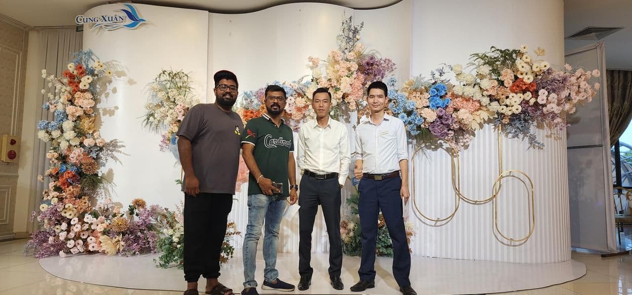 The XES team in front of a floral installation abroad