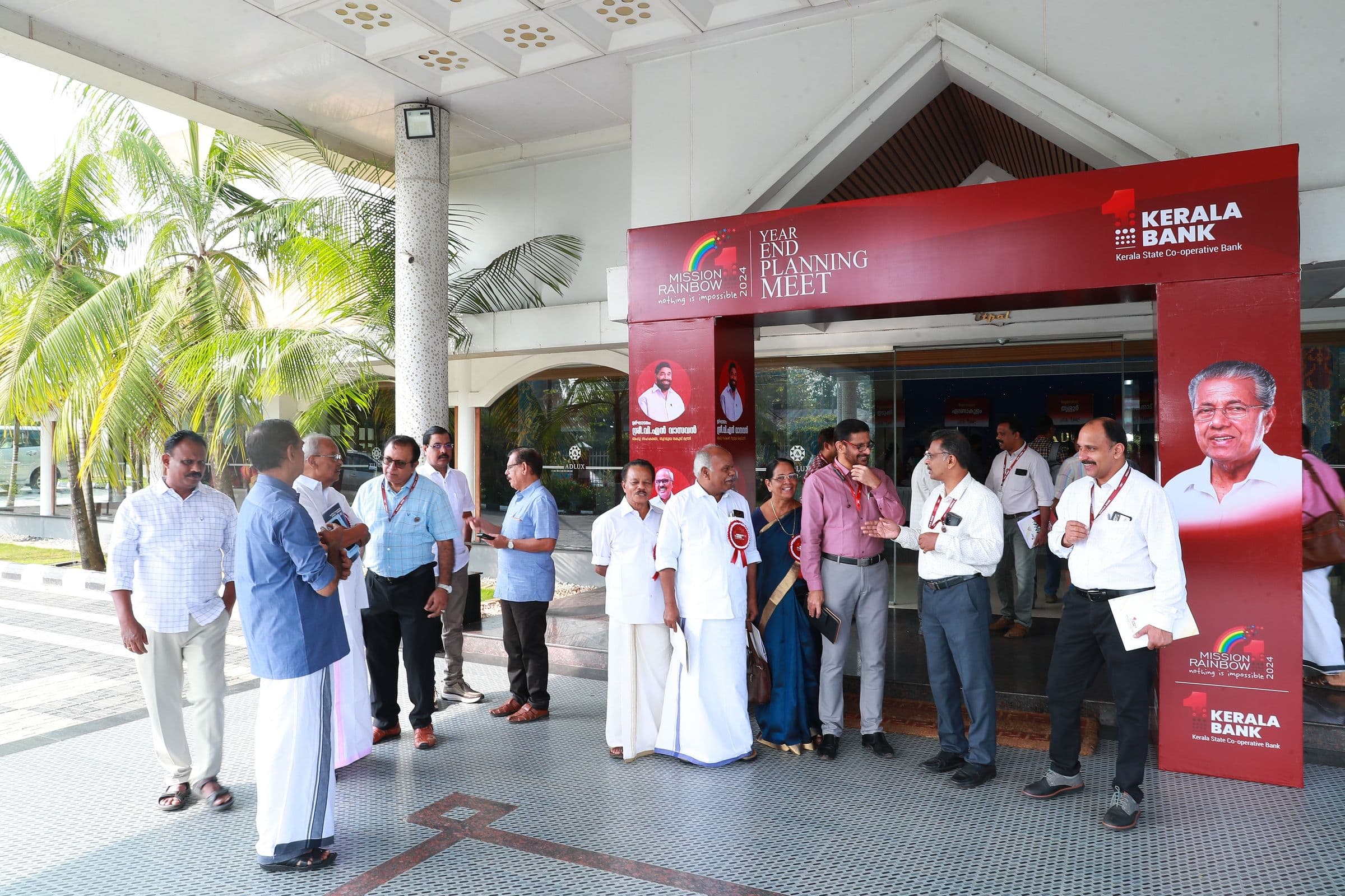Guests arrive at a Kerala Bank meet under branded signage