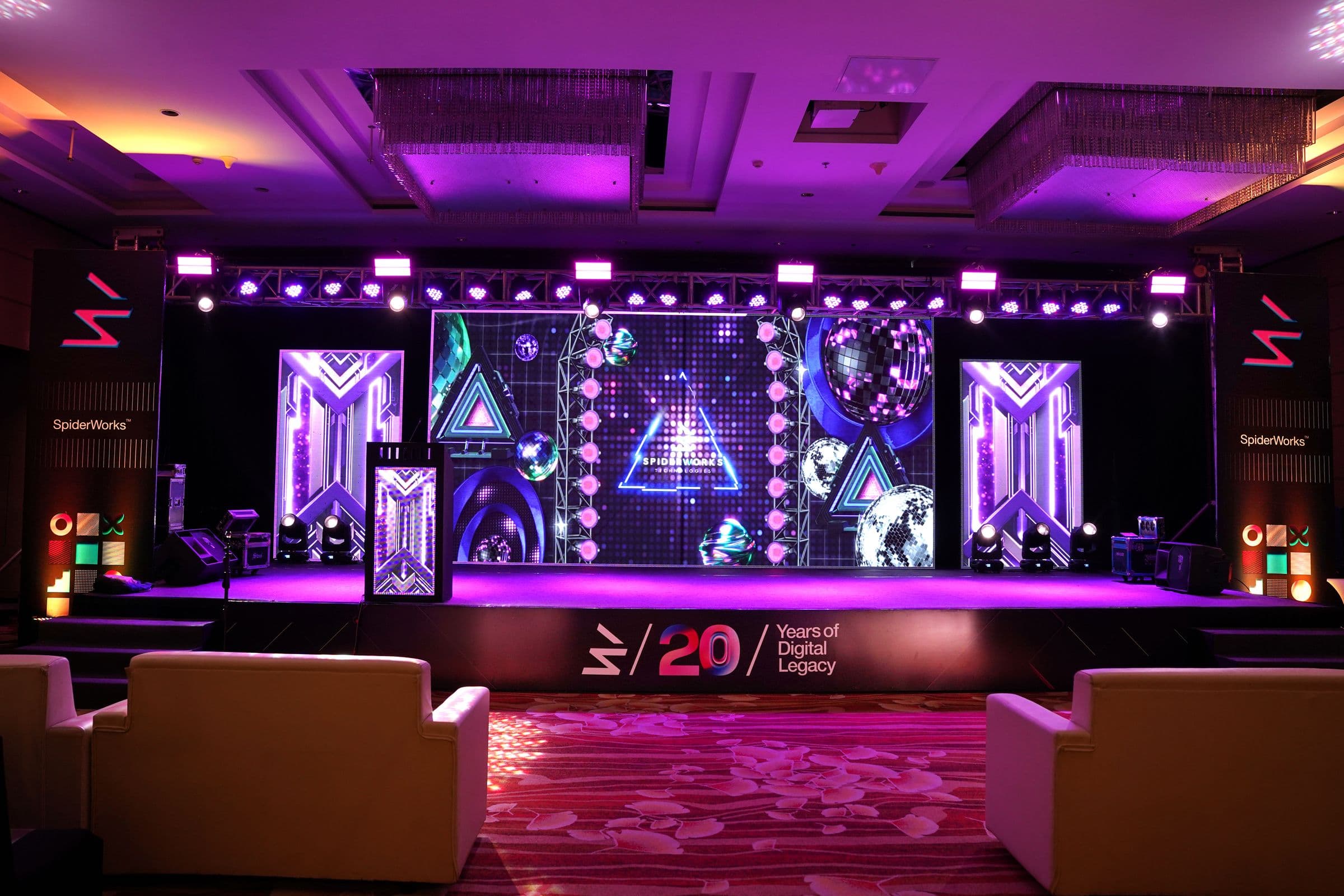 A stage with LED screens and purple lighting set for an awards evening