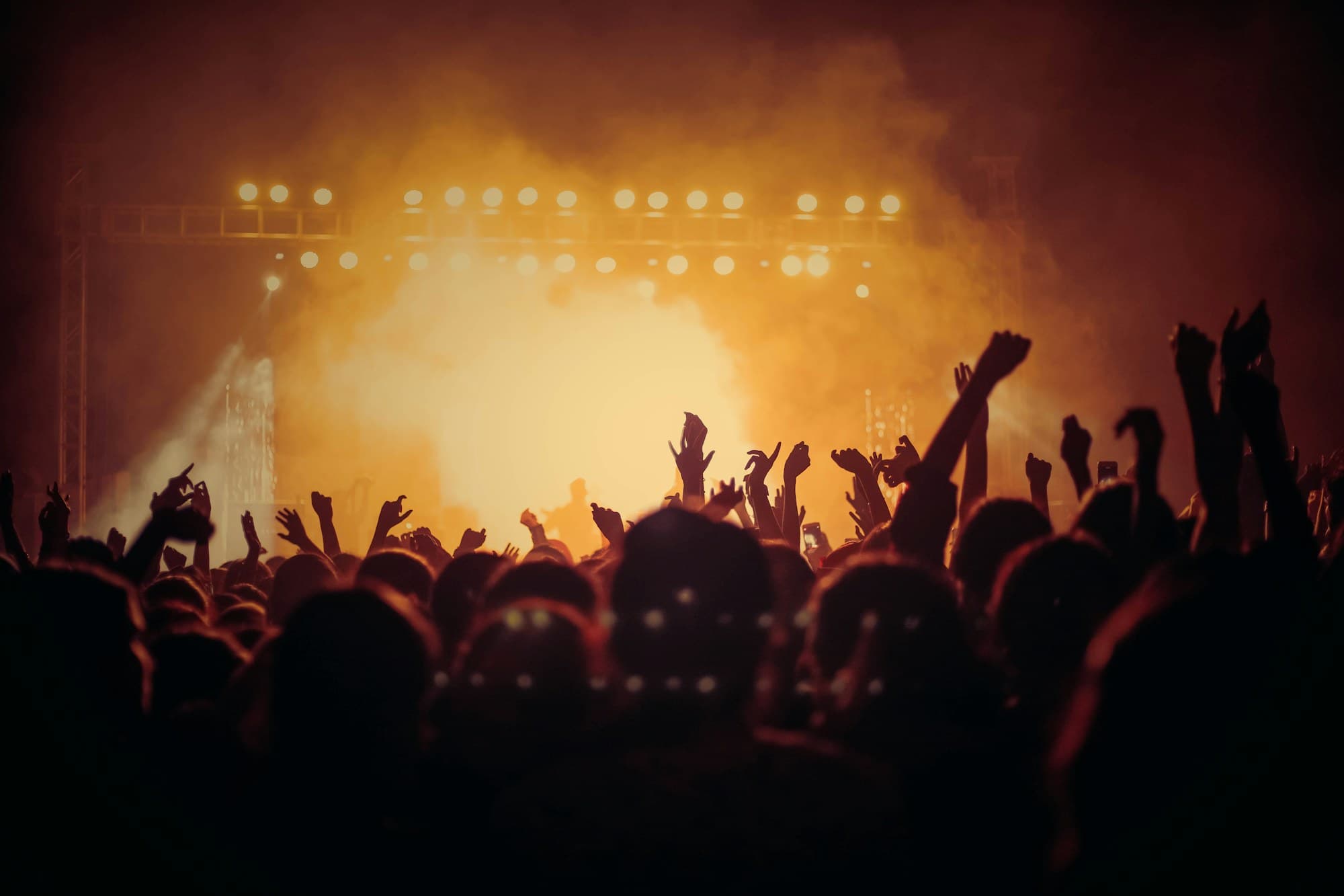 A concert crowd bathed in coloured stage light