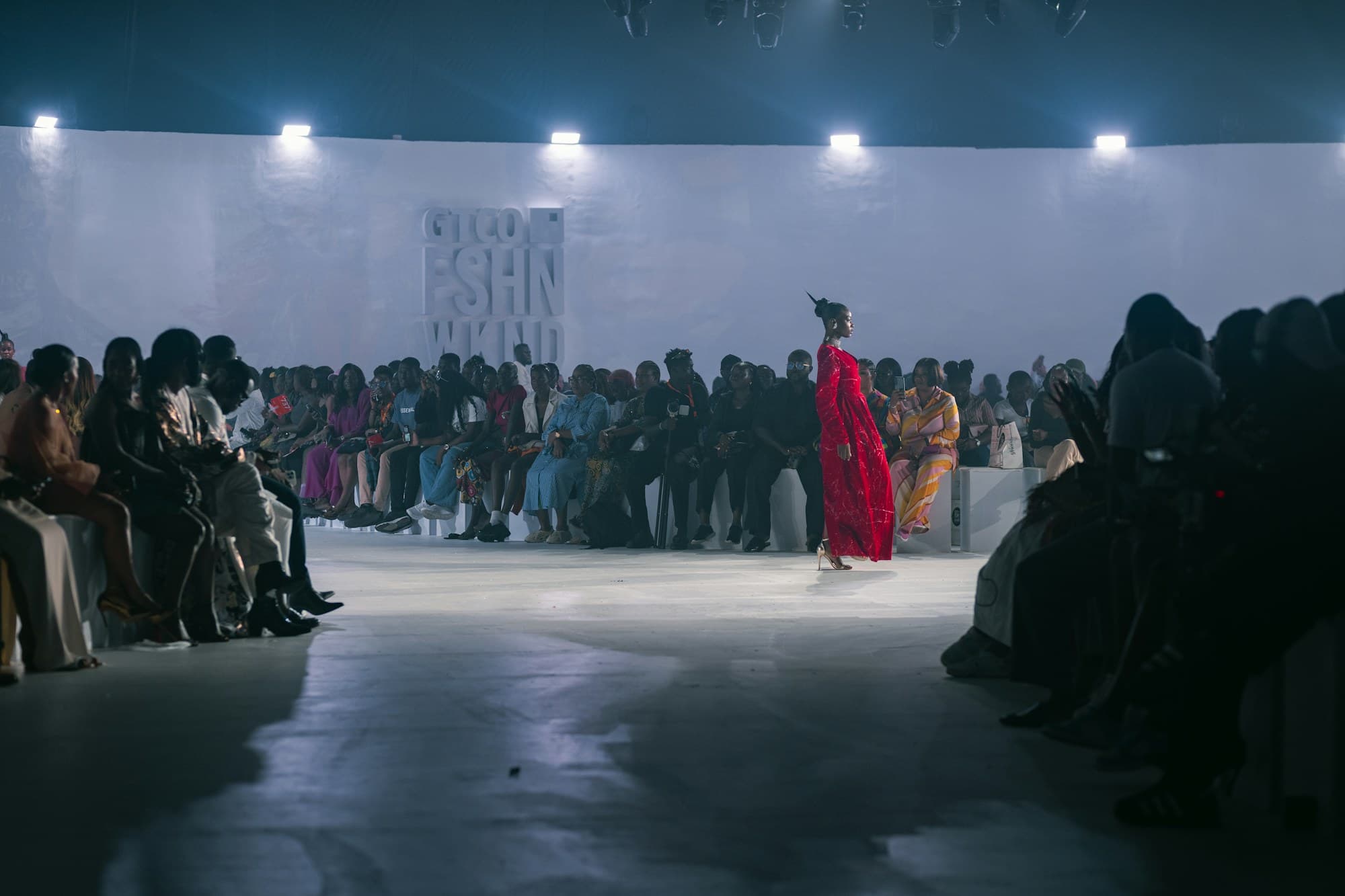 An audience watches attentively from the front row of a fashion show