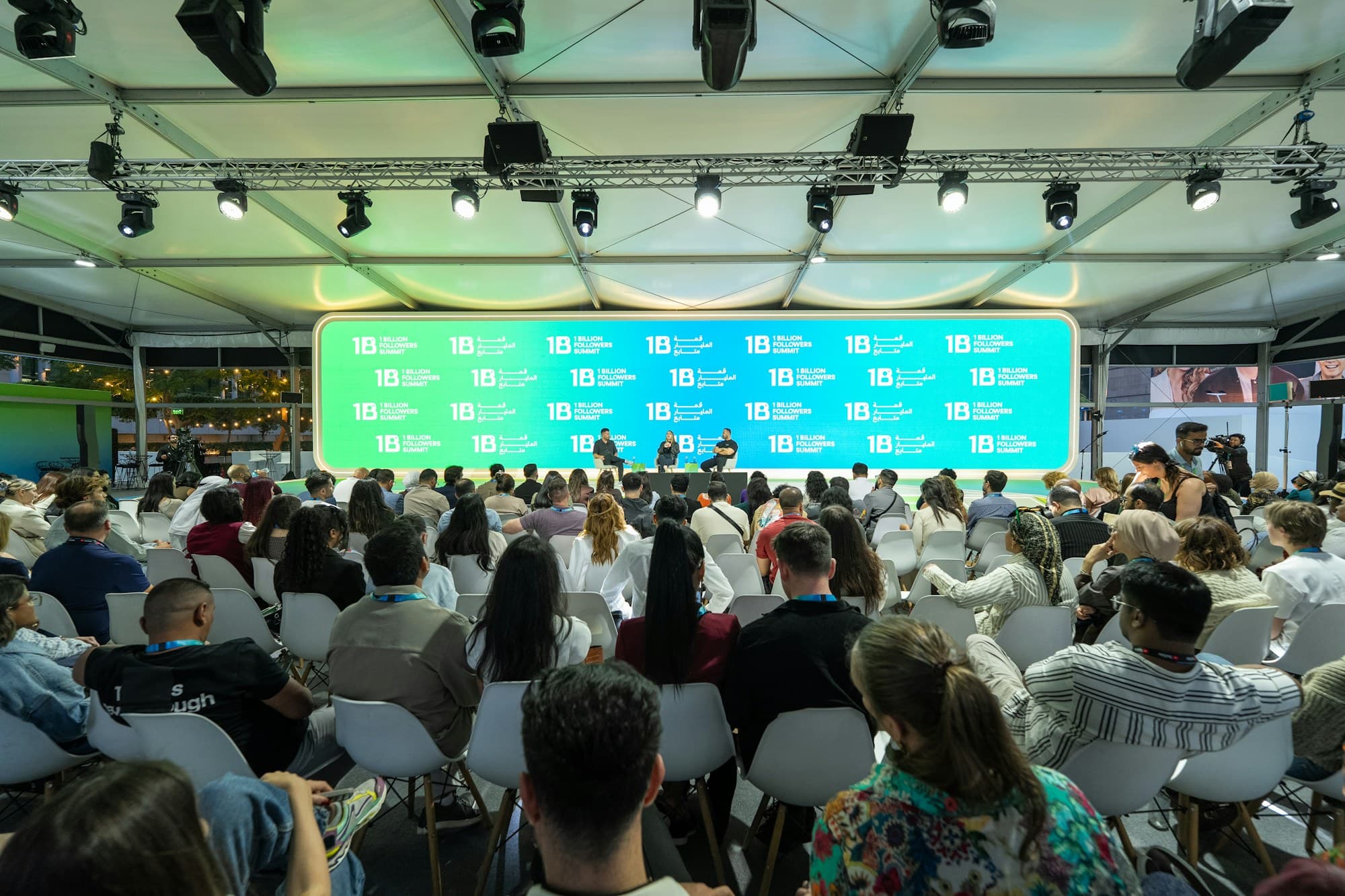 A speaker addresses a full house from the main stage of a brand summit