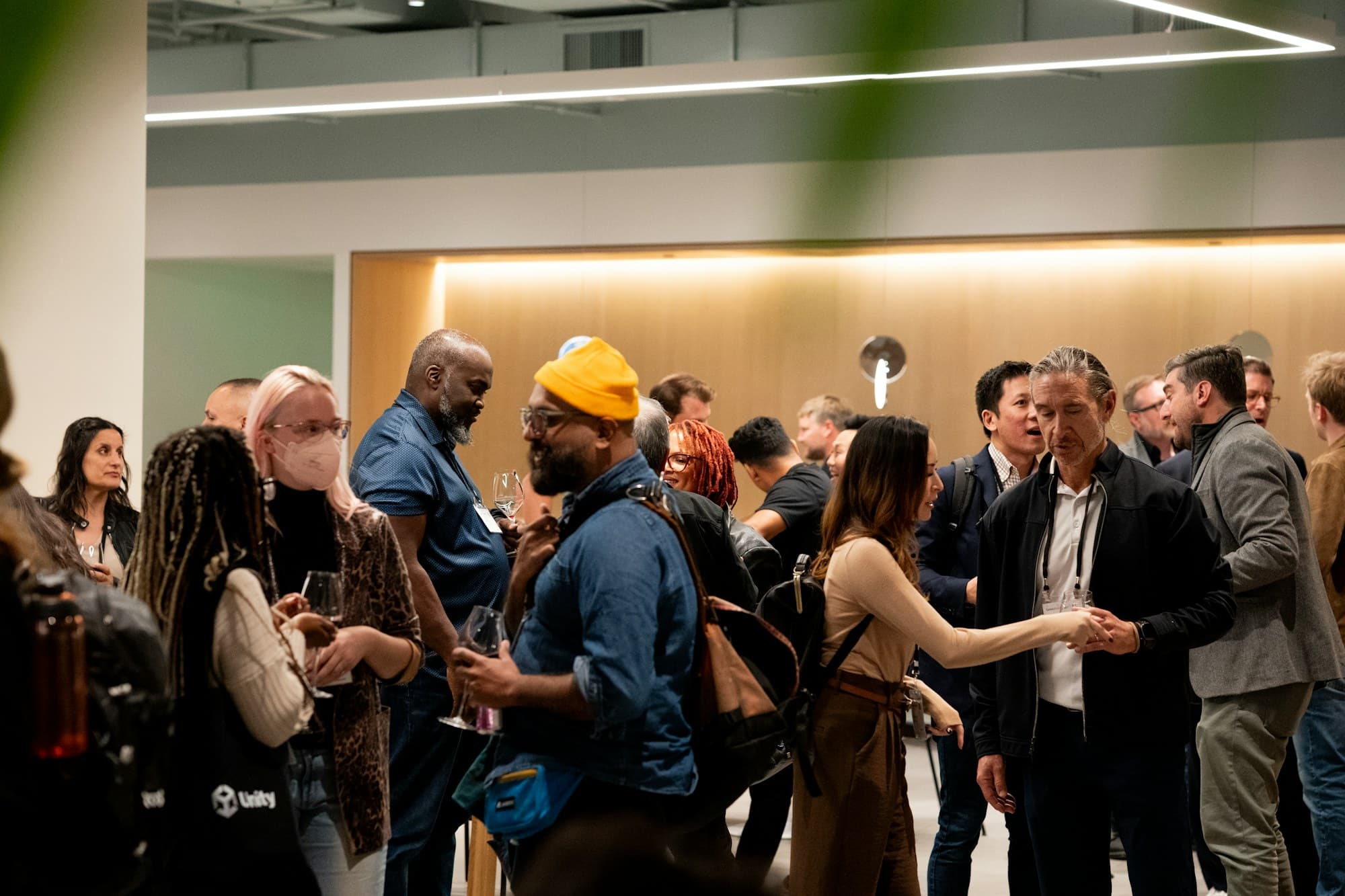 A diverse crowd mingles and converses at a conference reception